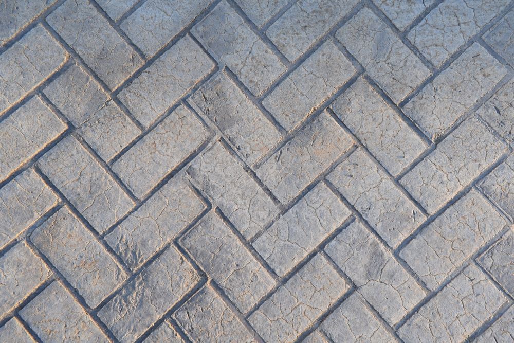 Herringbone brick pattern, gray bricks laid in a zig-zag design.