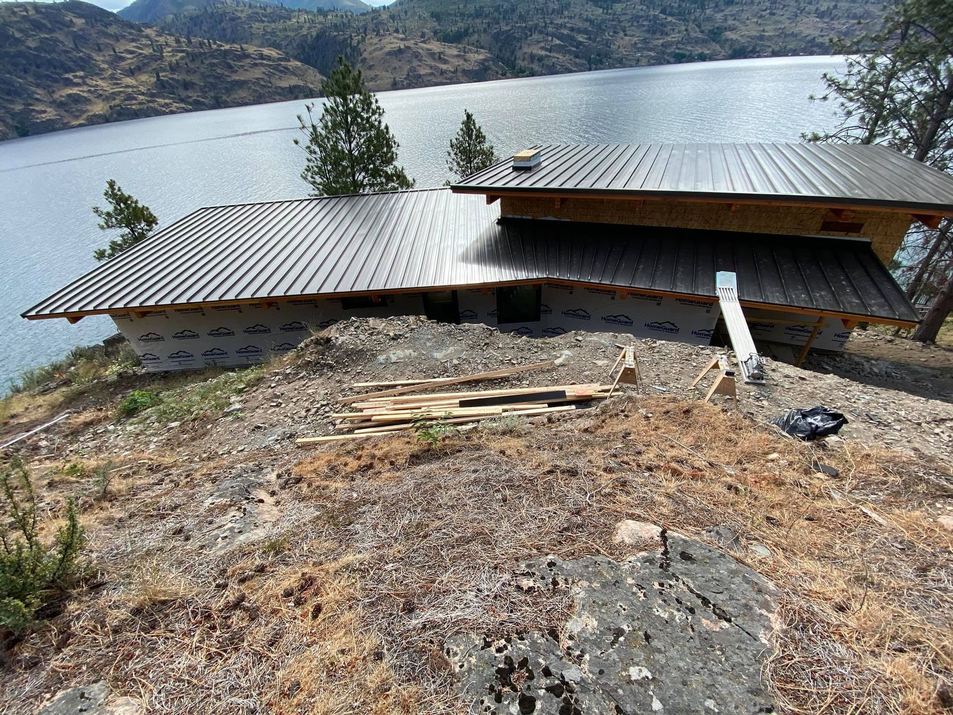 A house is being built on a hill overlooking a lake