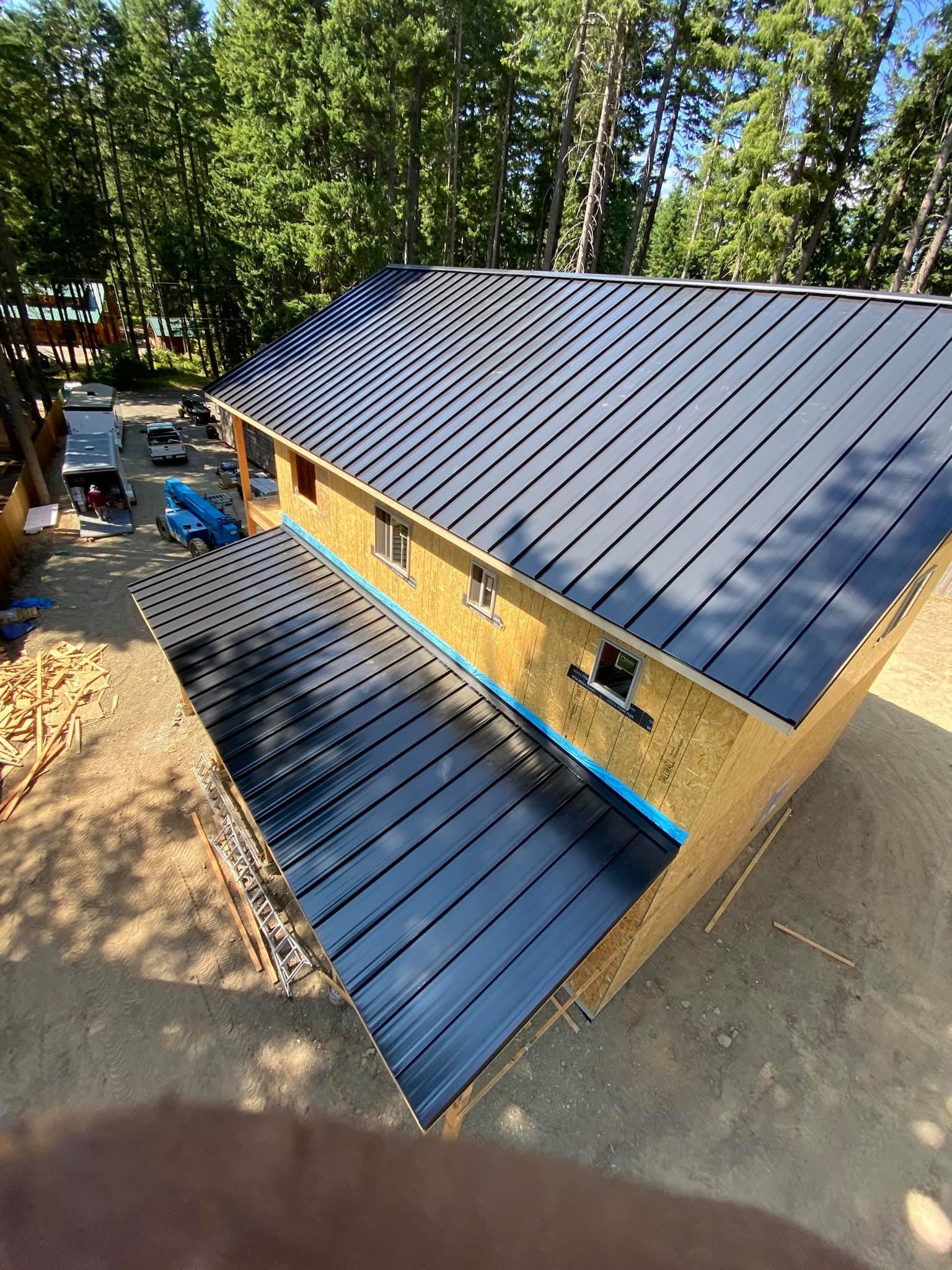 An aerial view of a house under construction with a black metal roof.