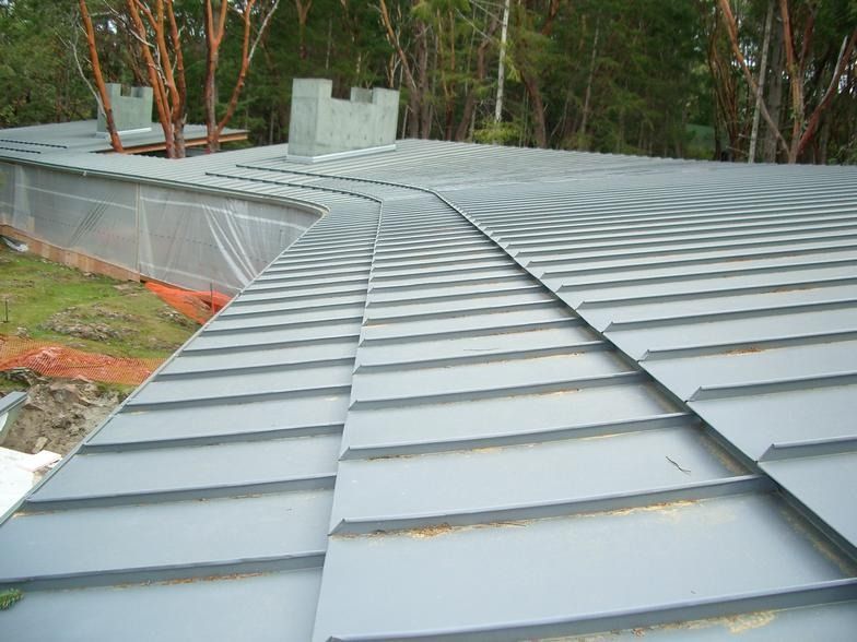 A close up of a roof with trees in the background