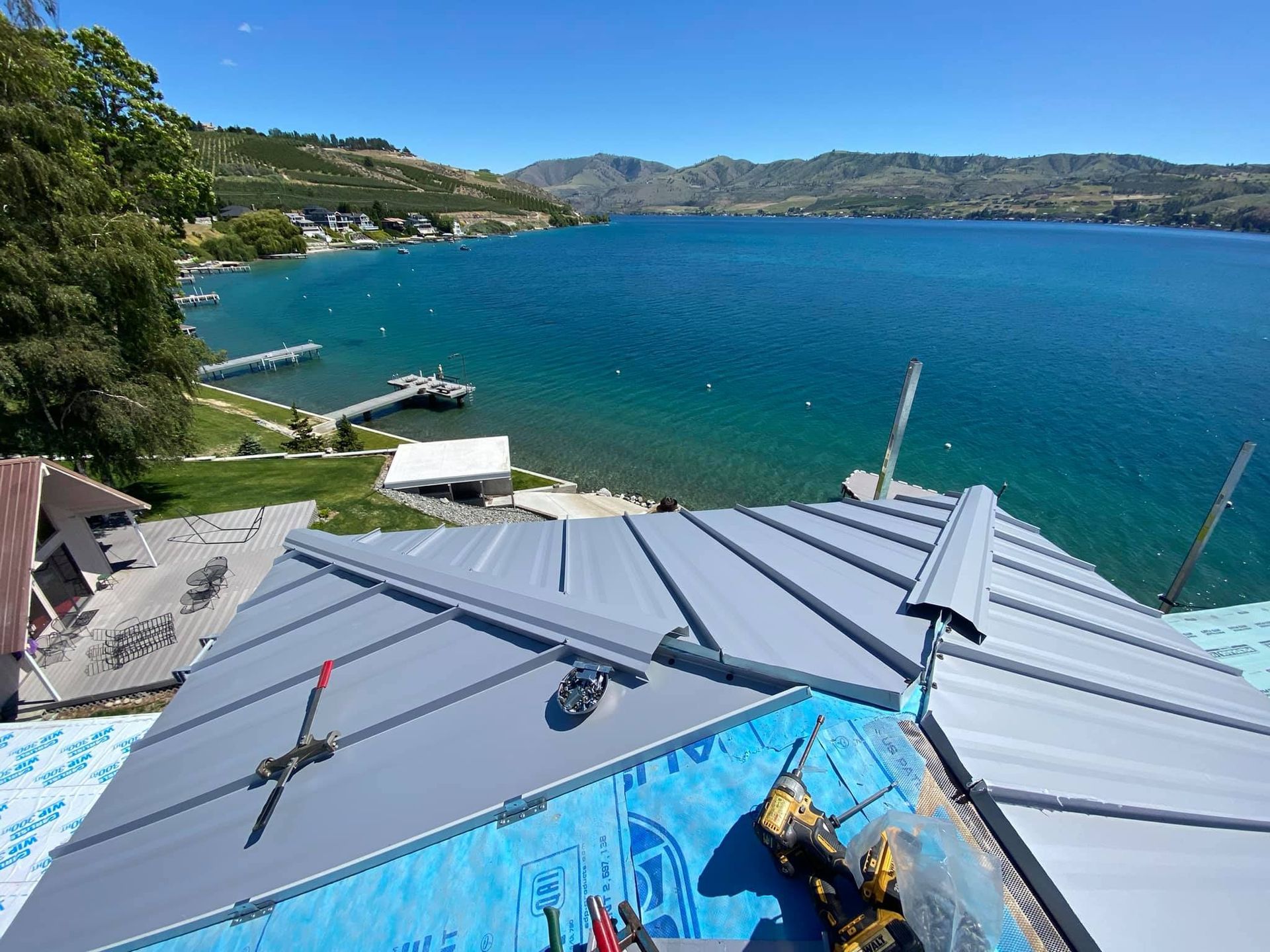 A roof with a view of a lake and mountains in the background.