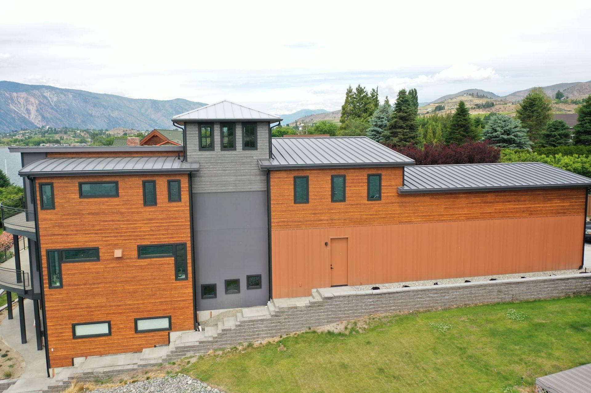 An aerial view of a large house with mountains in the background.