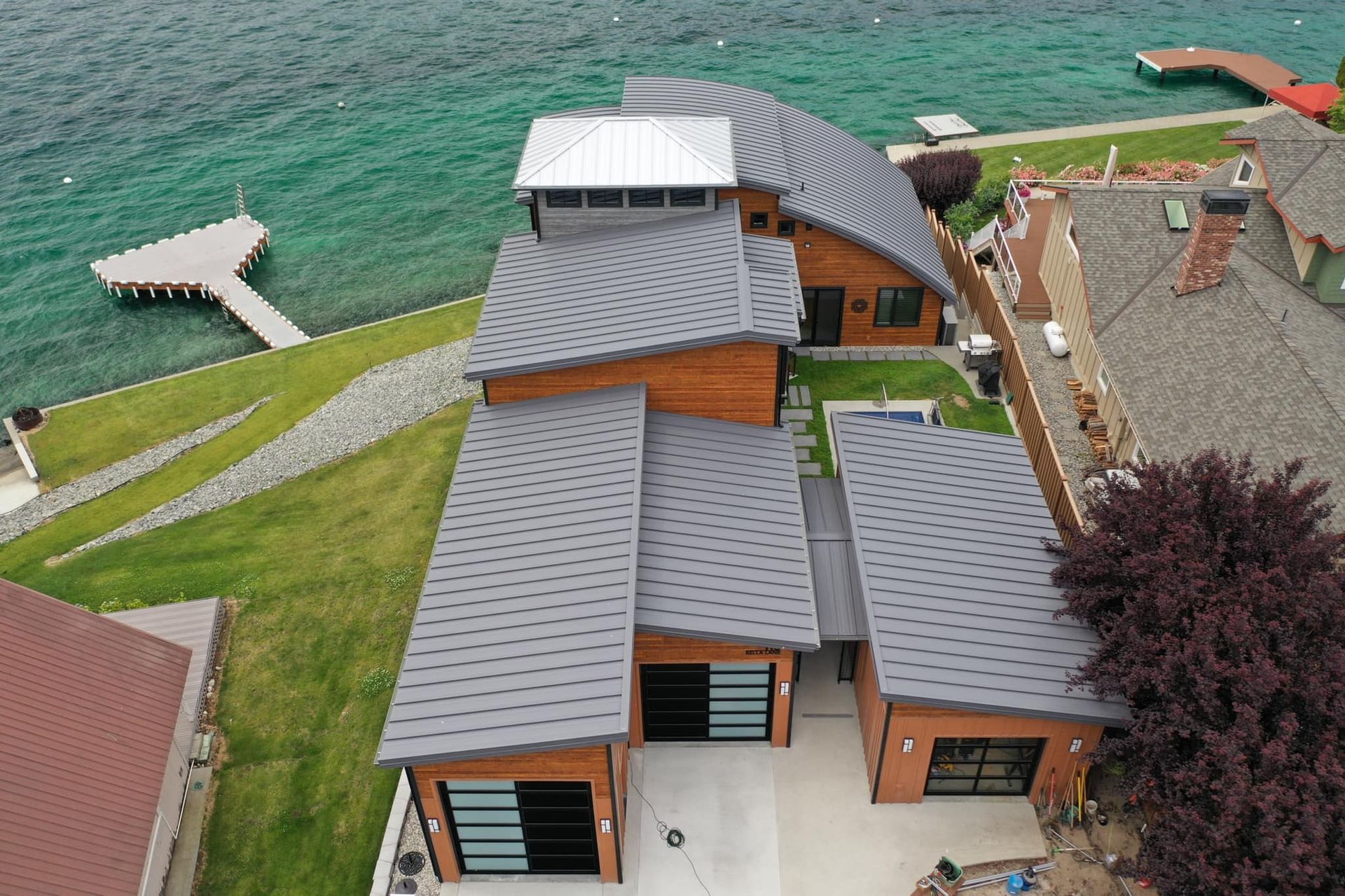 An aerial view of a large house next to a body of water.