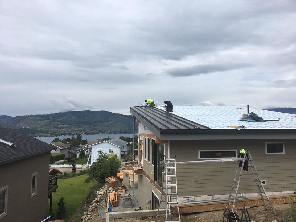 A group of people are working on the roof of a house.