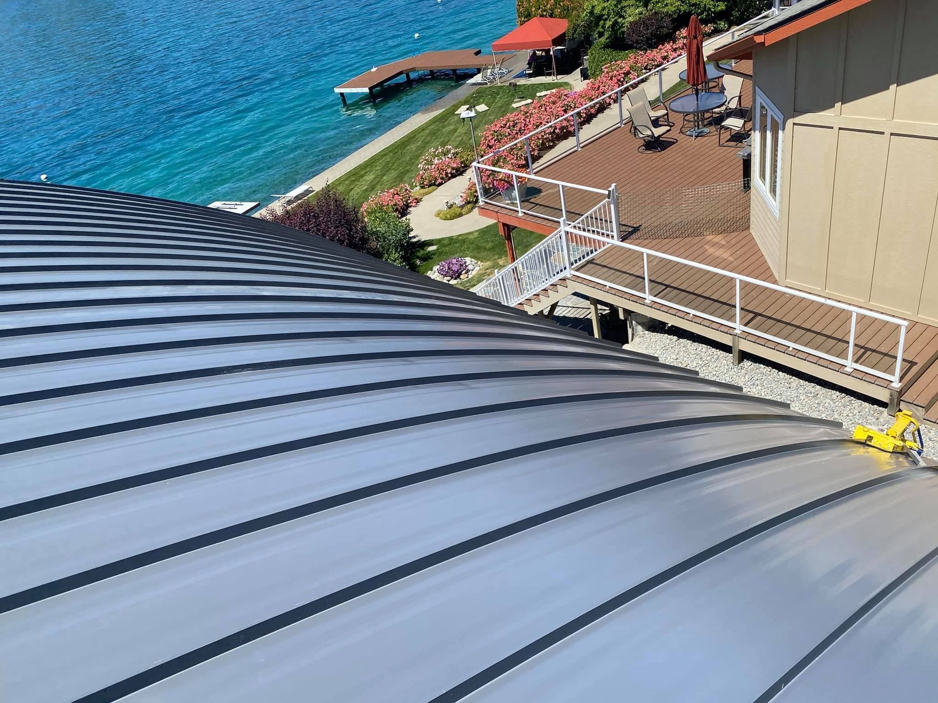 The roof of a house with a balcony overlooking a lake.