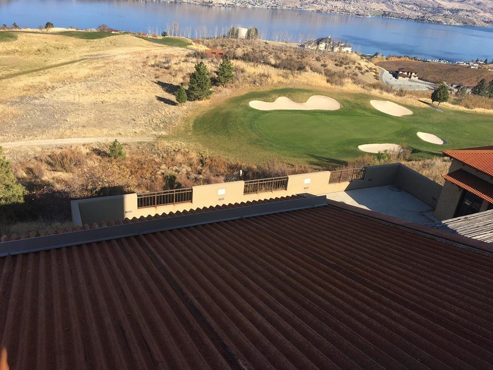 An aerial view of a golf course with a lake in the background