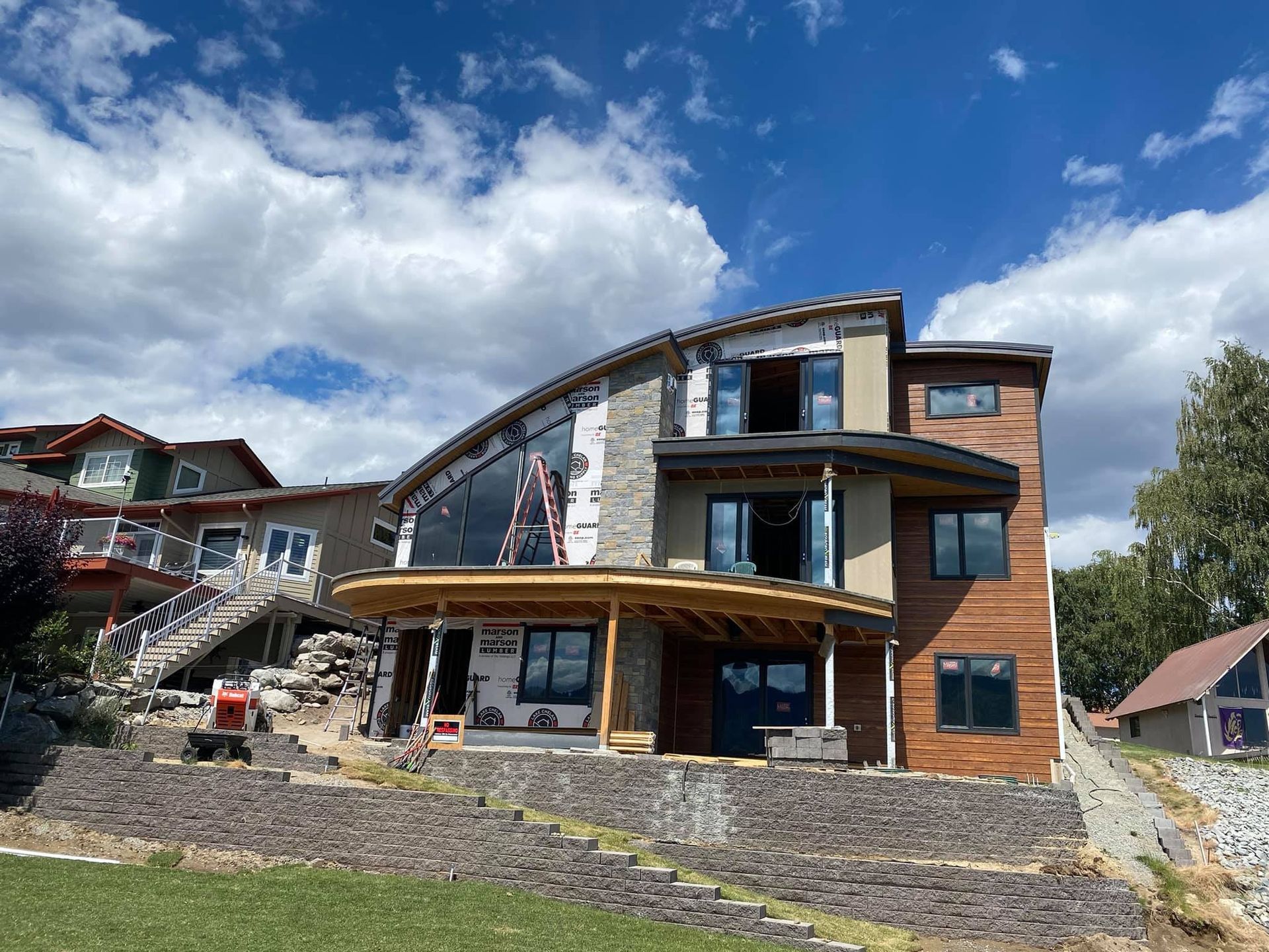 A large house is being built on a hill with a lot of windows.