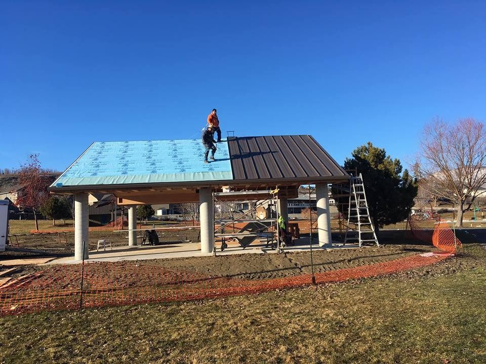 Two men are working on the roof of a building.