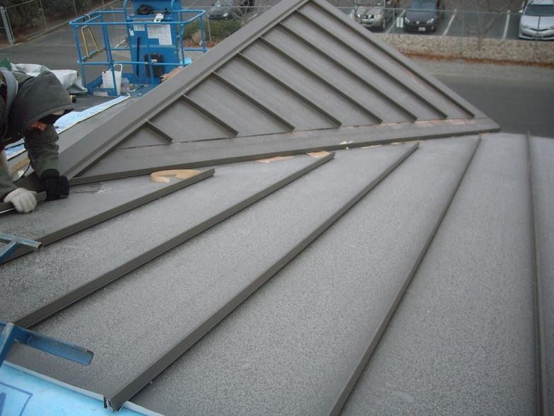 A man is working on the roof of a building.