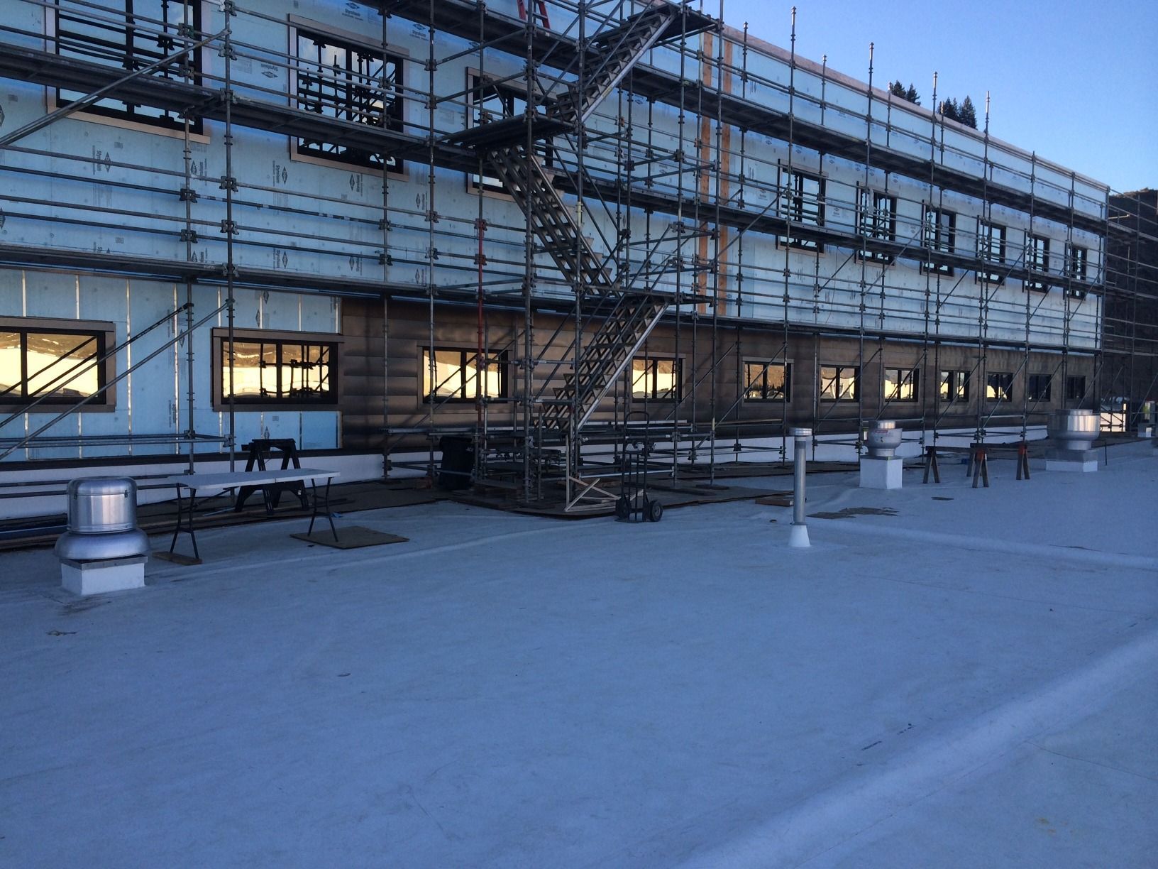 A large building under construction with scaffolding around it and a fire escape.