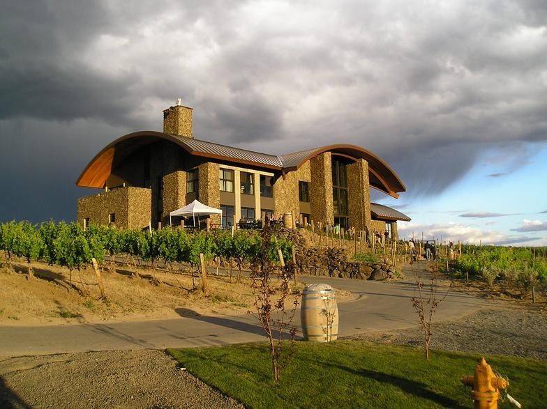 A large house with a curved roof is surrounded by vines and a fire hydrant