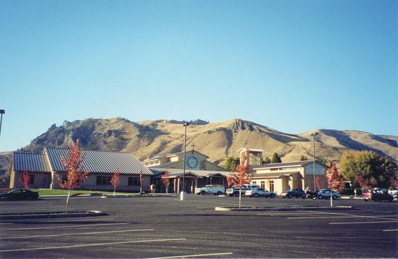 A parking lot in front of a building with mountains in the background