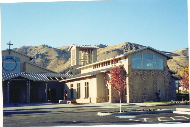 A picture of a church with mountains in the background
