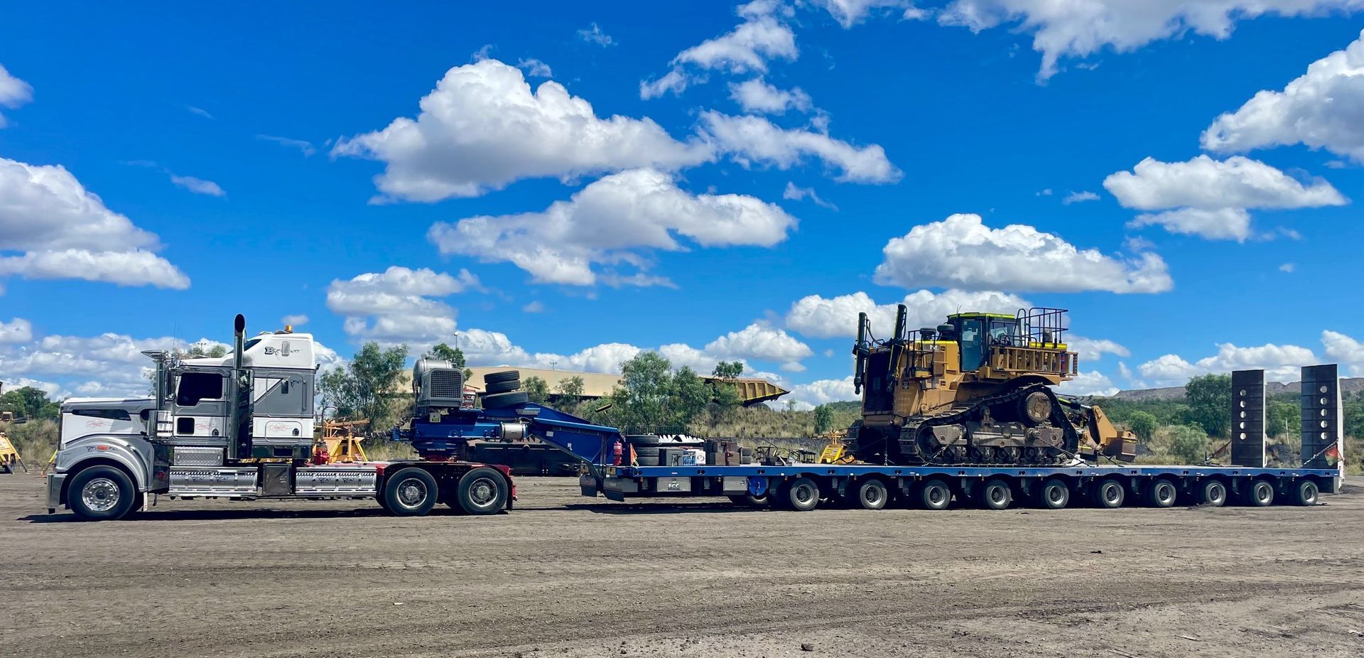 A large truck hauling heavy construction equipment on a trailer — ECC Heavy Haulage in Ormeau, QLD