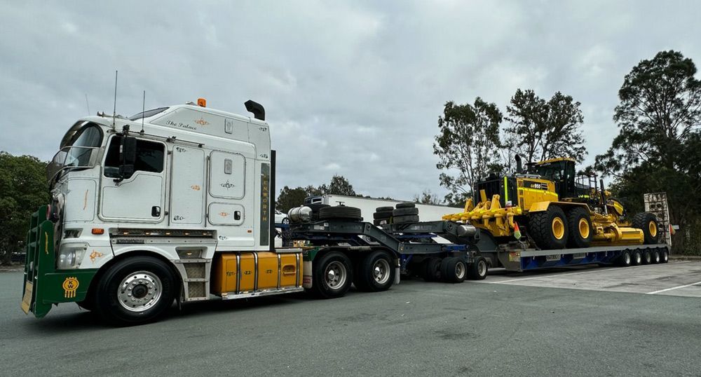 A Large White Semi Truck Is Driving Down a Road — ECC Heavy Haulage in Cairns, QLD