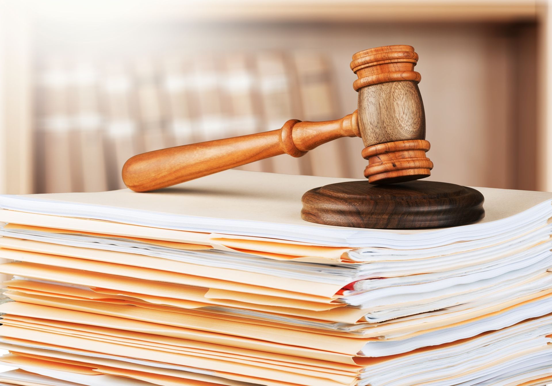 Wooden gavel on top of a stack of documents, in a law office.