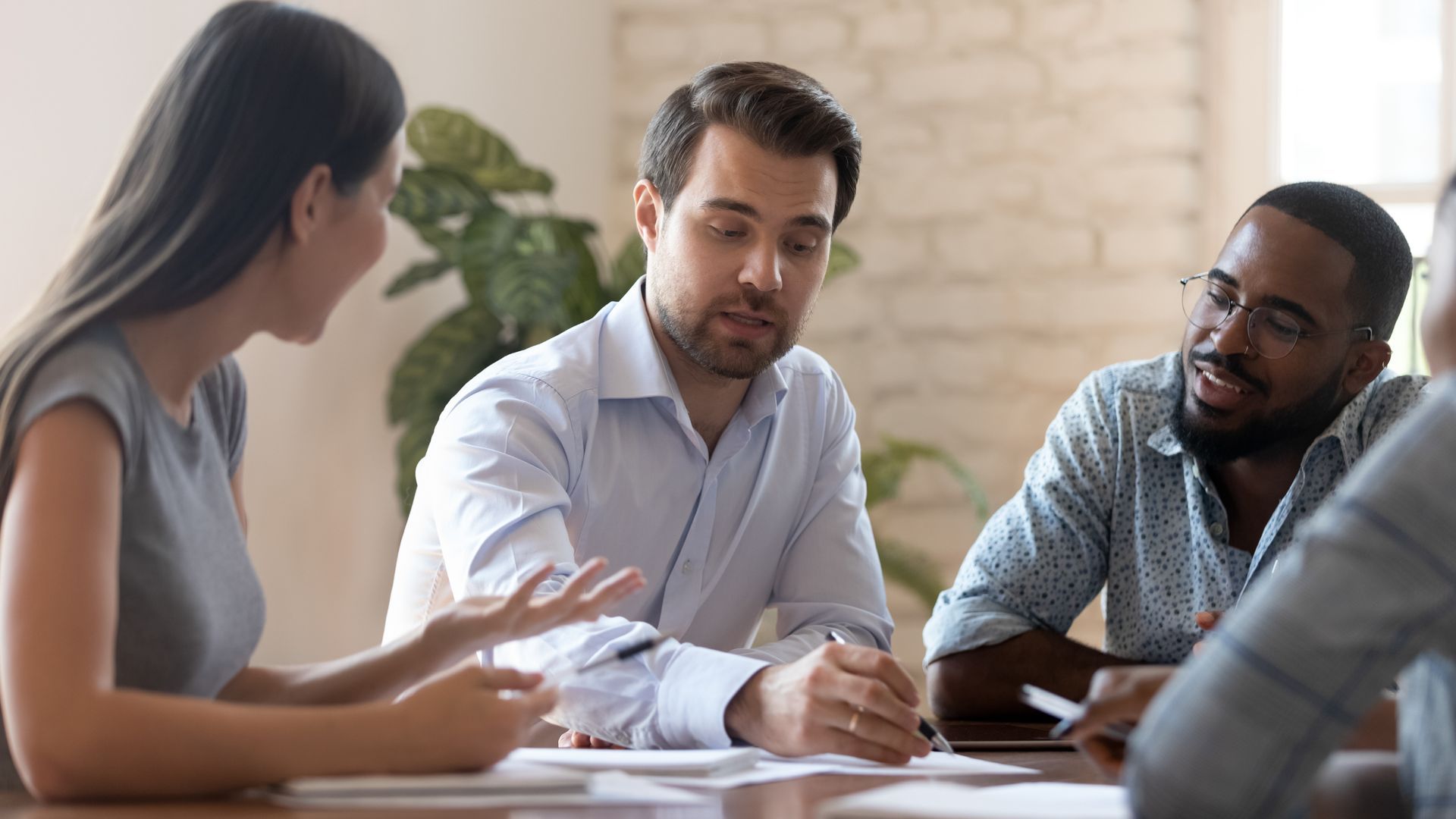 Business team in meeting, discussing documents at a table.
