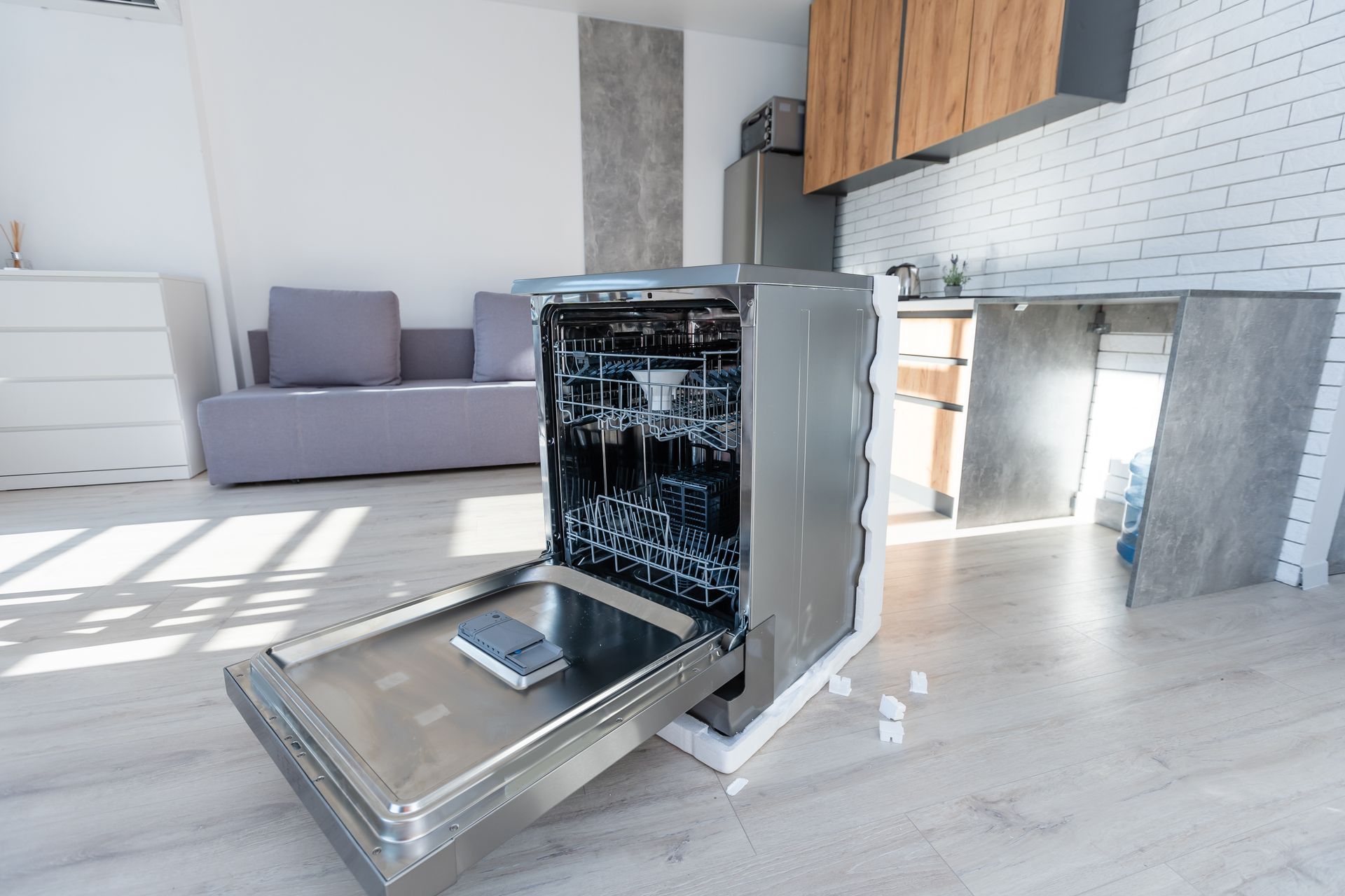 Dishwasher with door open in a modern kitchen. Stainless steel appliance.