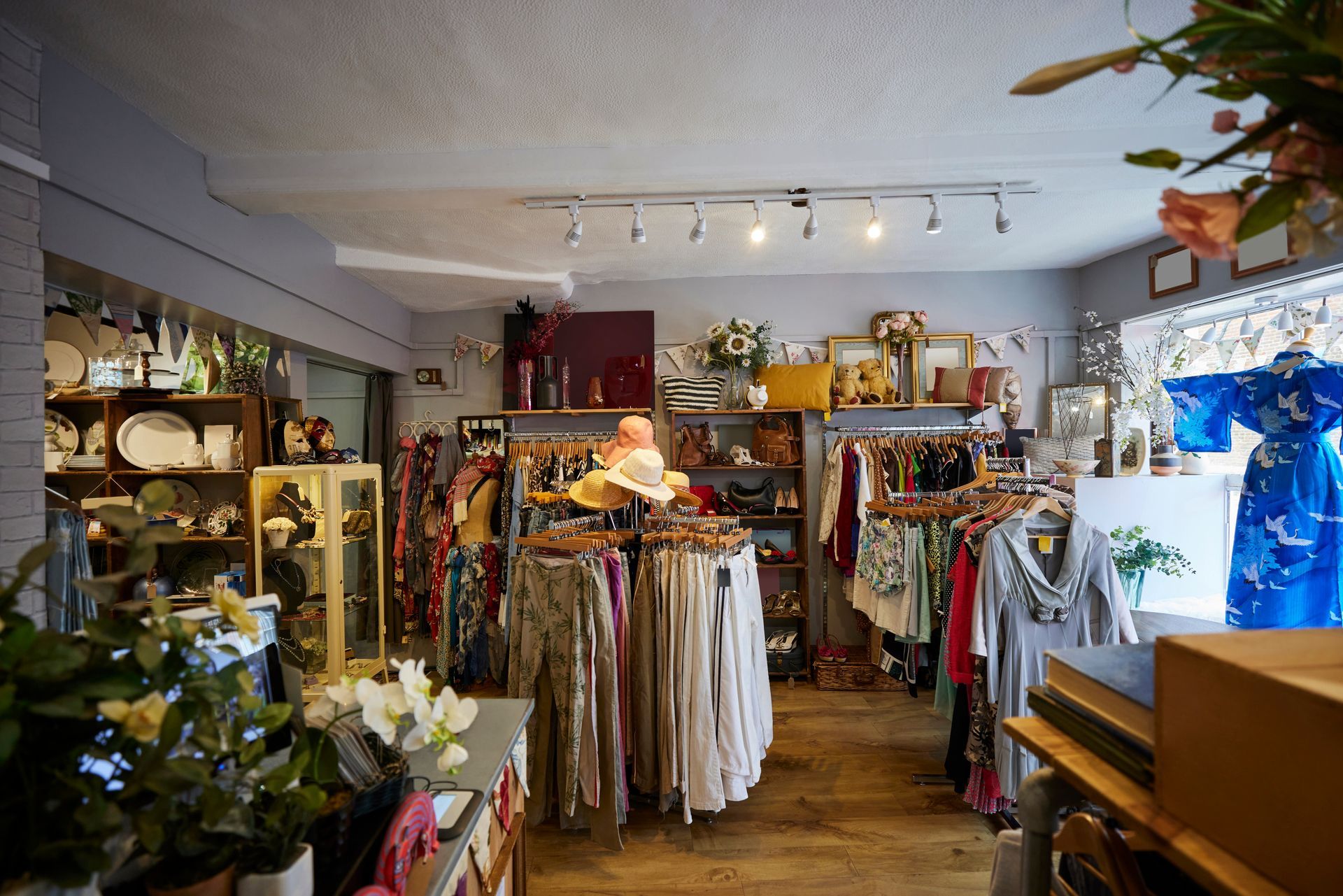 Interior of a vintage clothing and antique shop, with racks of clothes, displays, and decorations.