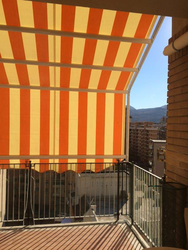 tenda da sole a righe gialle e arancioni