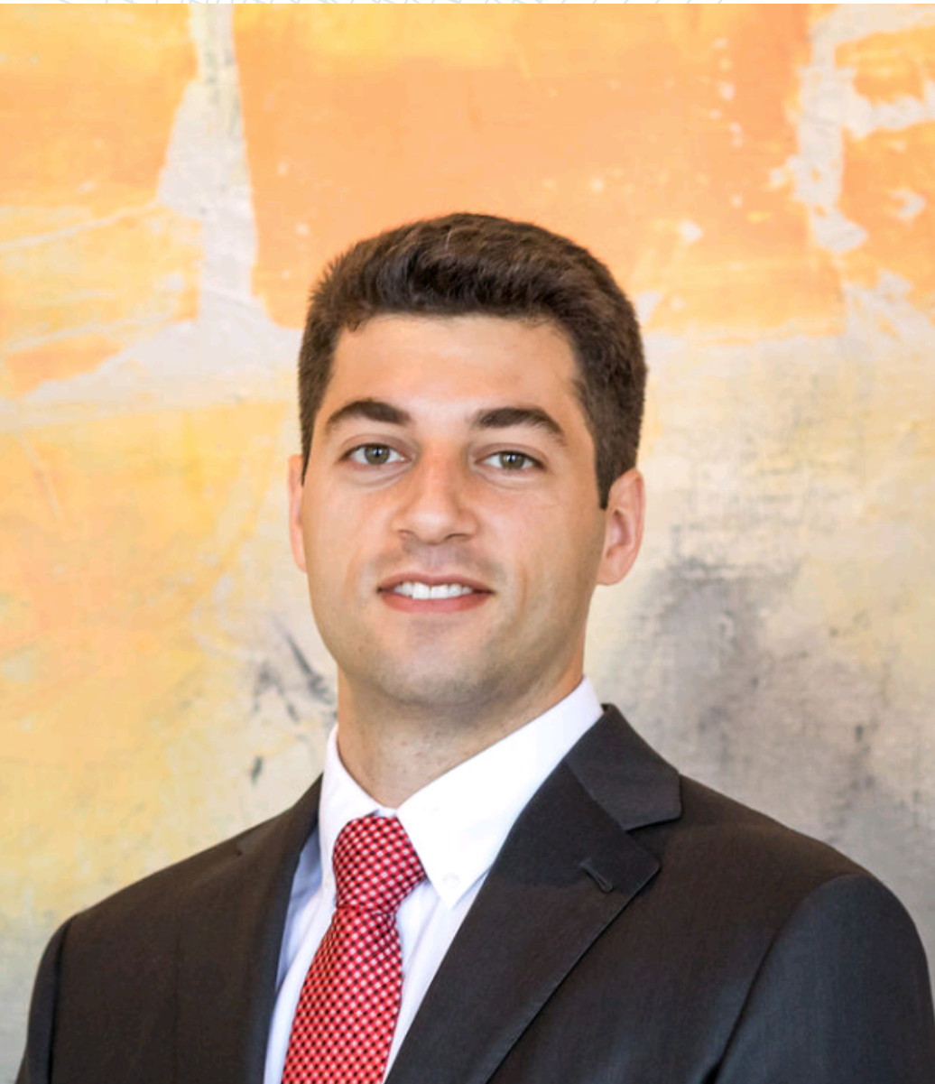 A man in a suit and tie is smiling for the camera