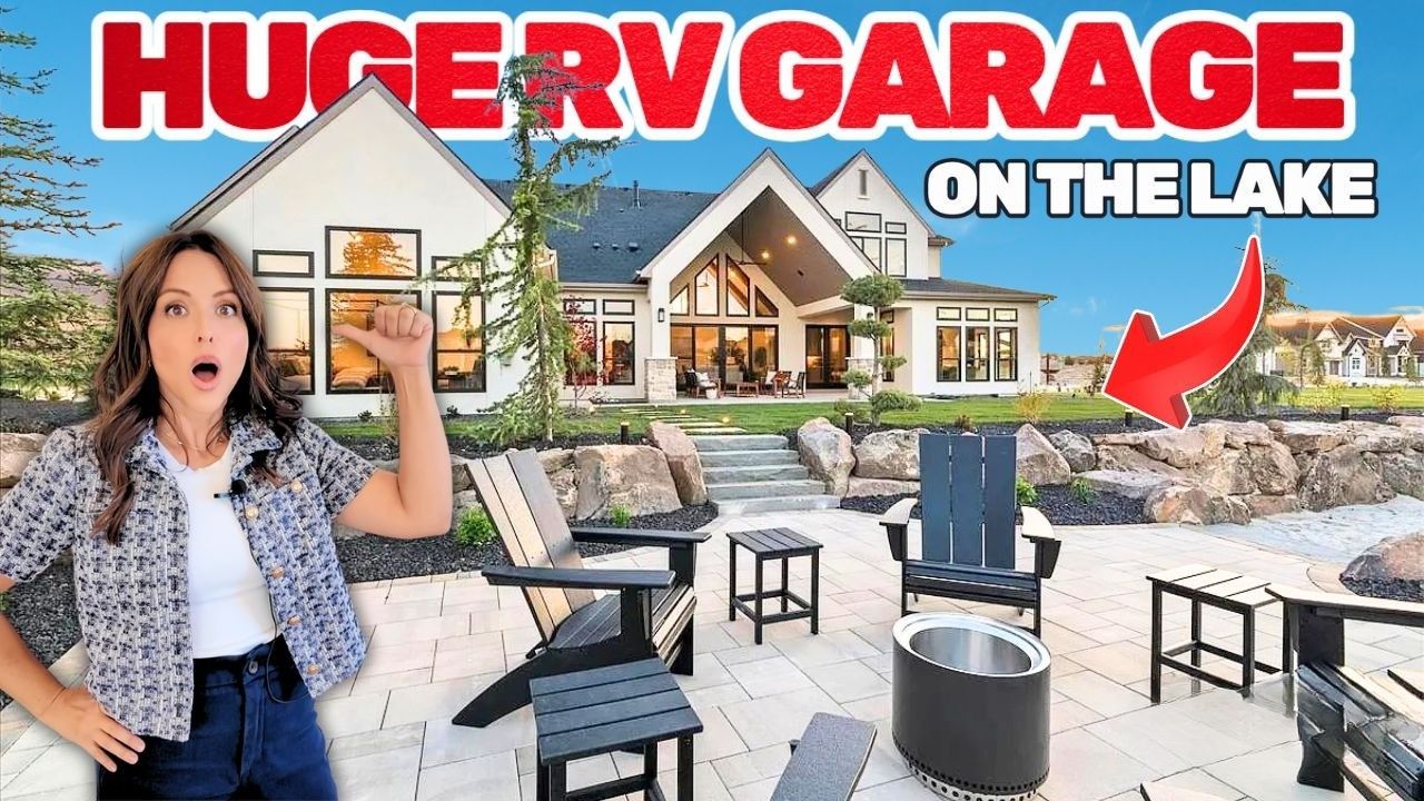 Woman points to a lake house with an RV garage, patio furniture, and stunned expression.