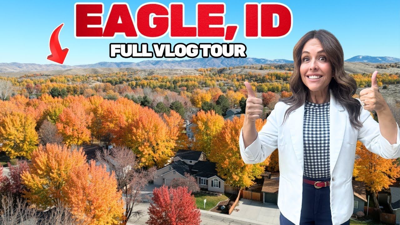 Woman giving thumbs up in front of fall trees and town in Eagle, Idaho.