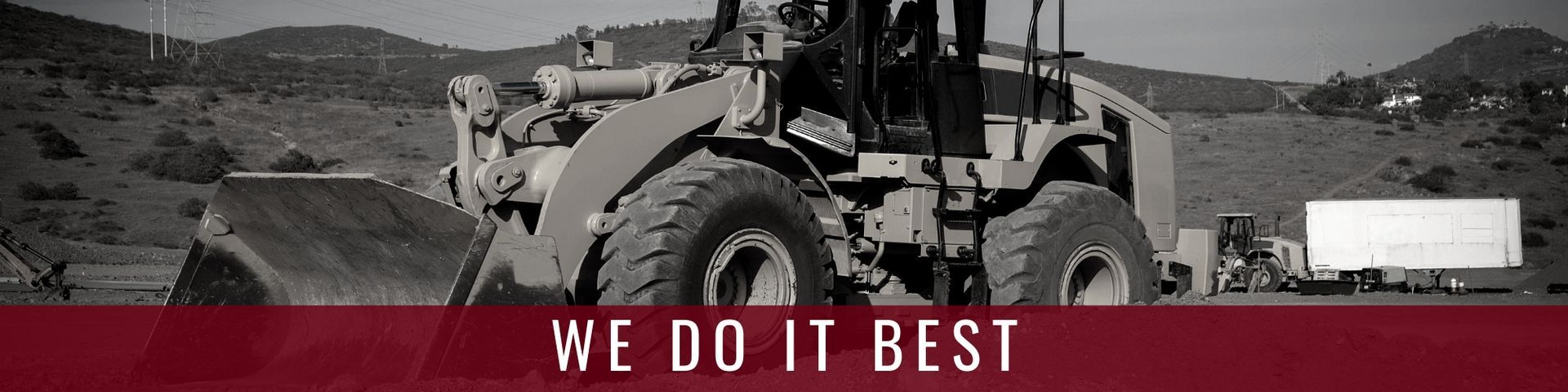 A yellow front-end loader sits on a construction site with a red banner at the bottom containing the text 