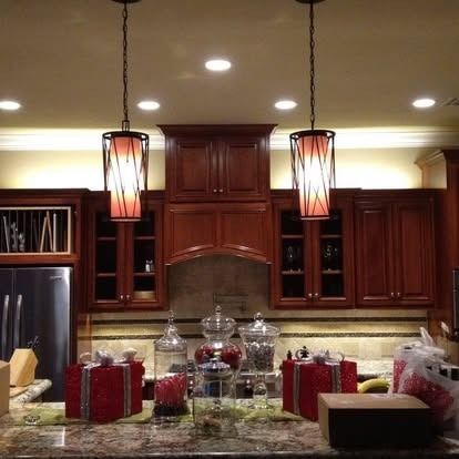 Kitchen counter with two pendant lights, wooden cabinets, and two red gift boxes.