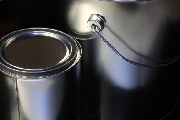 Two shiny silver paint cans, one open, reflecting light.
