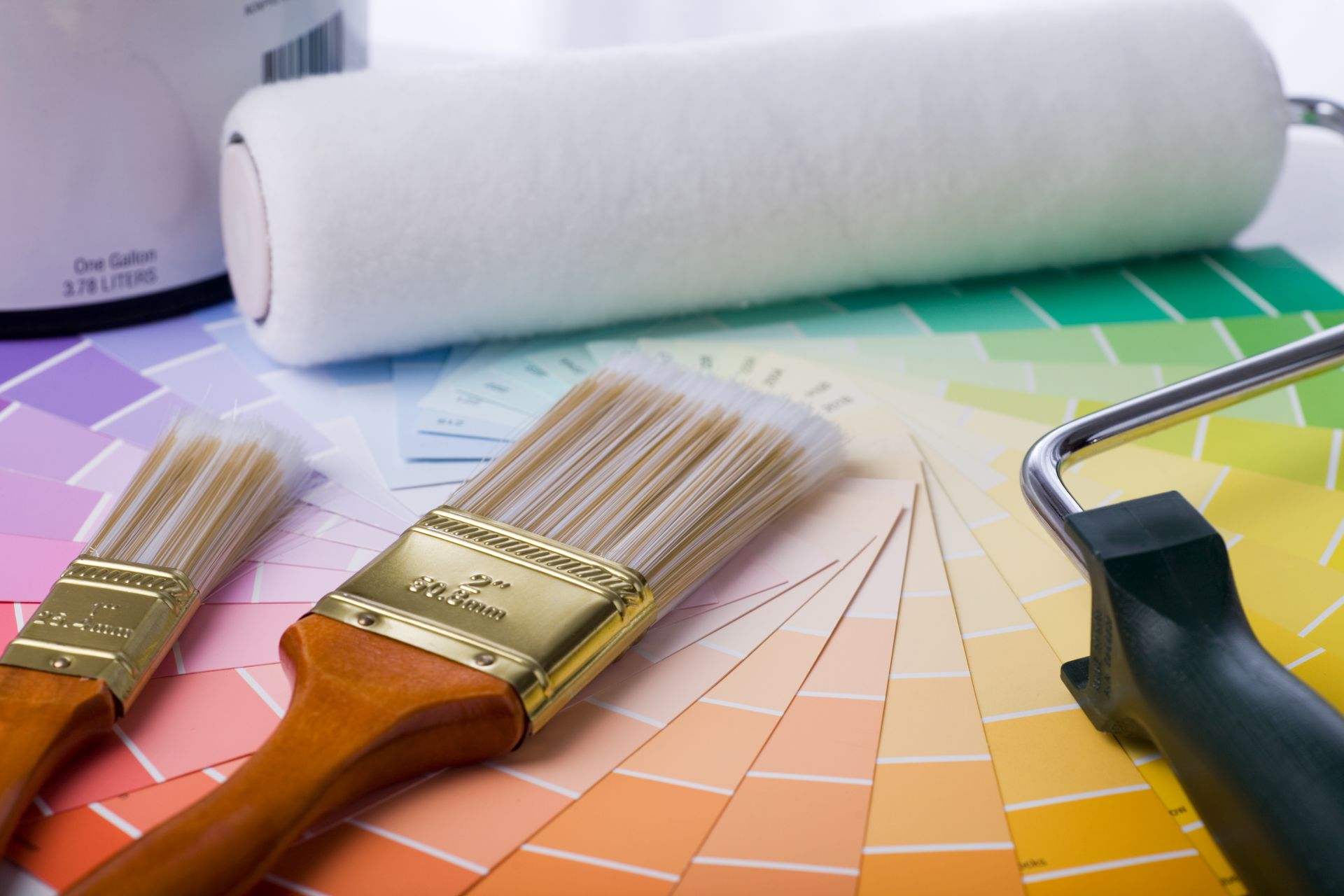 Paint supplies: paint can, paint roller, paint brushes, color swatches.