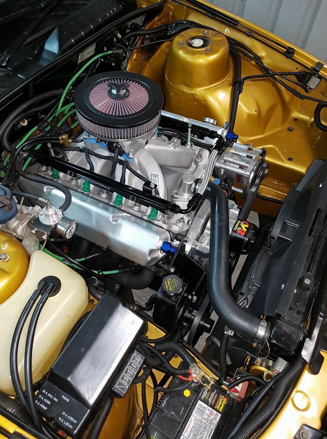 A close up of the engine of a yellow car