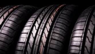 A close up of three tires stacked on top of each other on a black background.