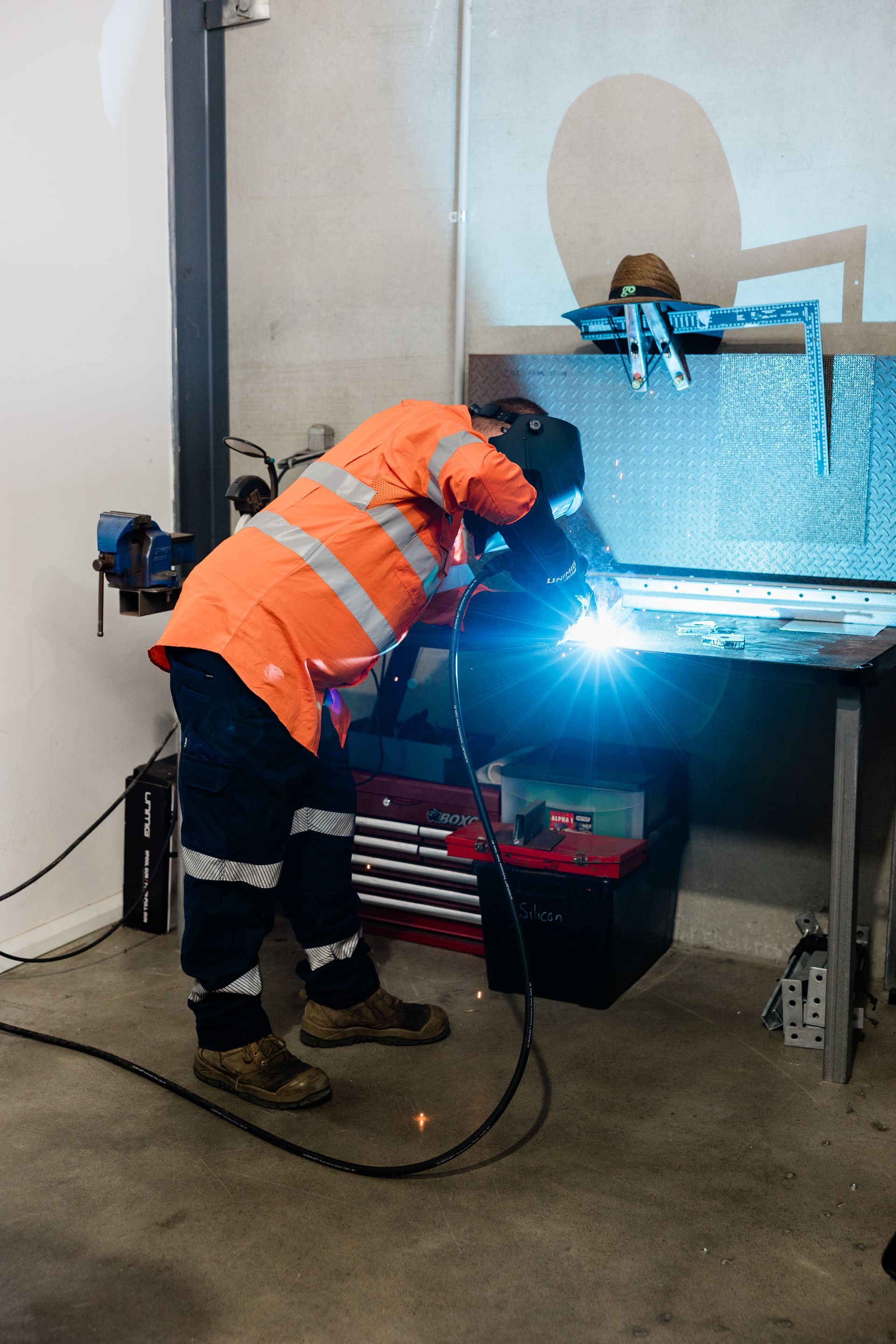 A Worker Welds Metal at a Workbench — API Engineering in Charmhaven, NSW