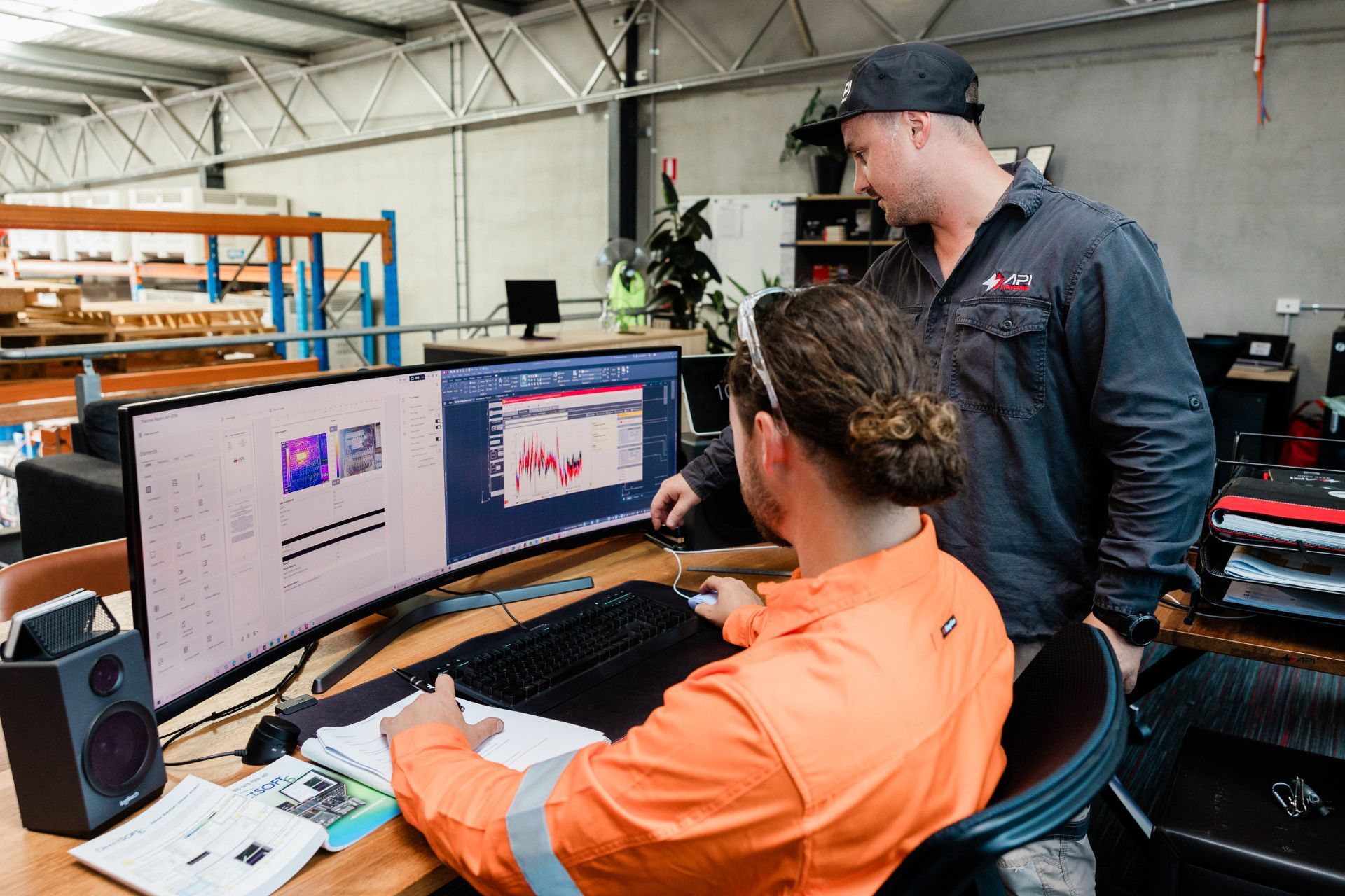Two People Looking at Data on a Curved Monitor — API Engineering in Charmhaven, NSW