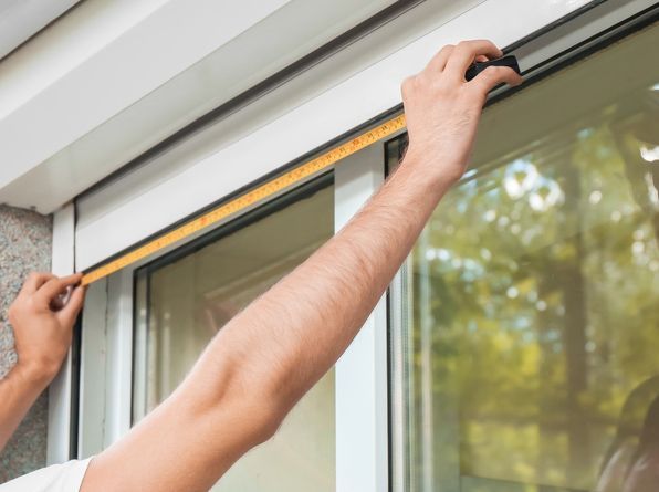 A Man is Measuring a Window With a Tape Measure  — Wow Clean Cairns in Bayview Heights, QLD