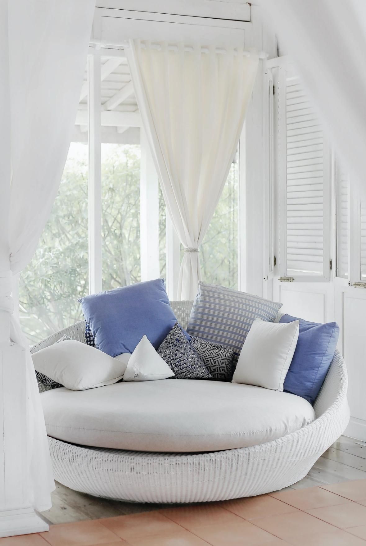 A Round Couch With Blue and White Pillows in a Living Room Next to a Window — Wow Clean Cairns in Bayview Heights, QLD