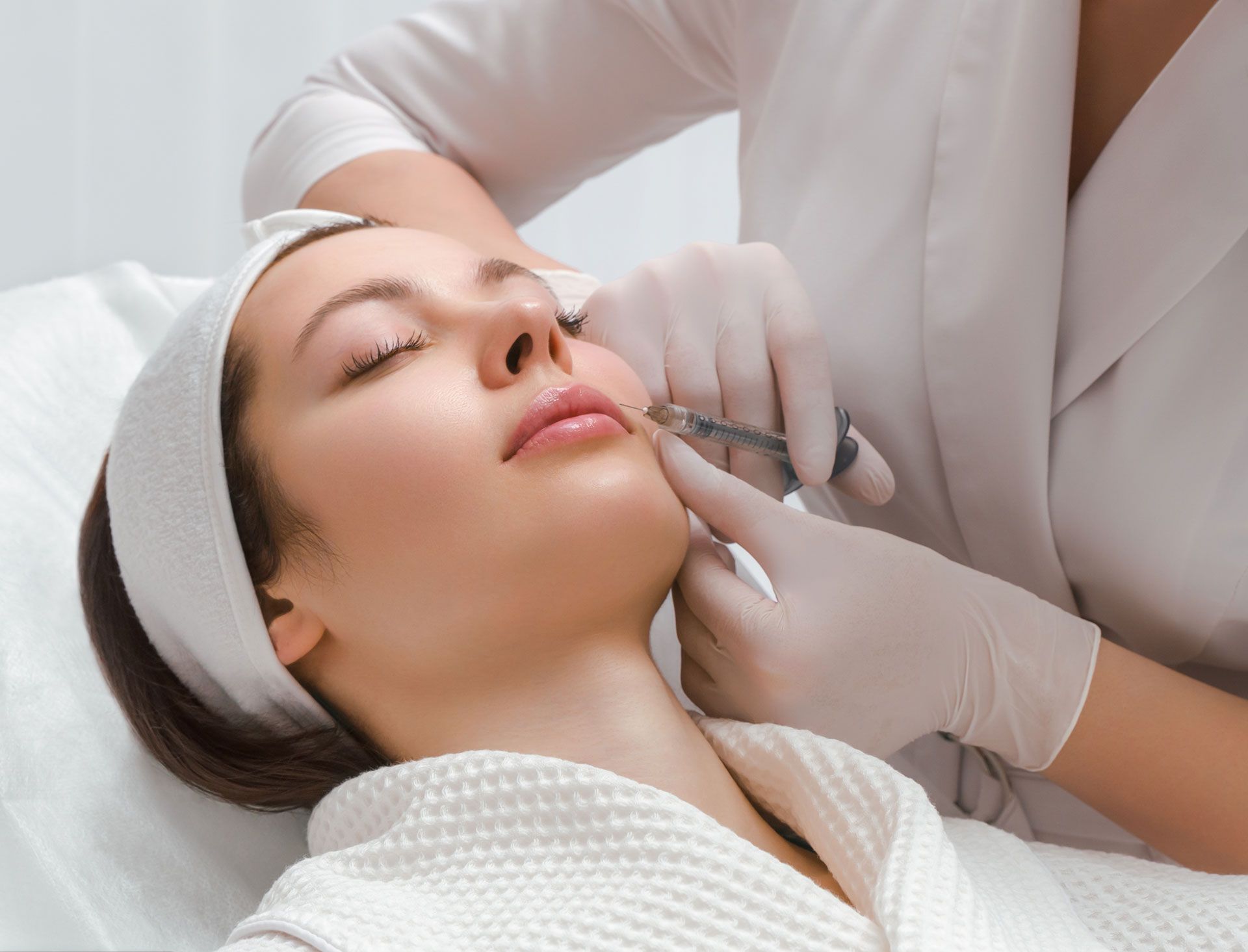 Cosmetic treatment on a relaxed client receiving a facial injection in a spa setting