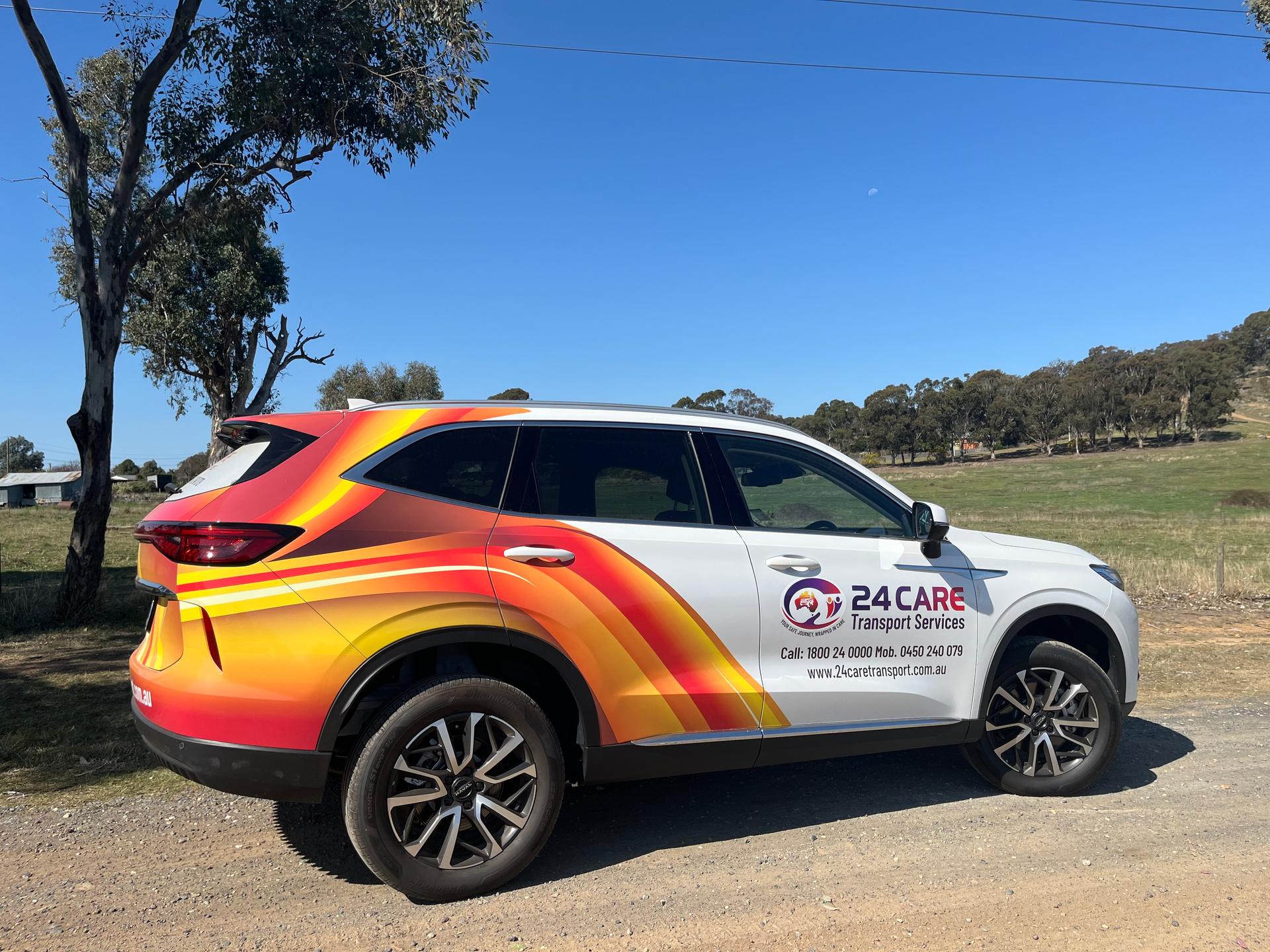 A colorful suv is parked on the side of a dirt road.