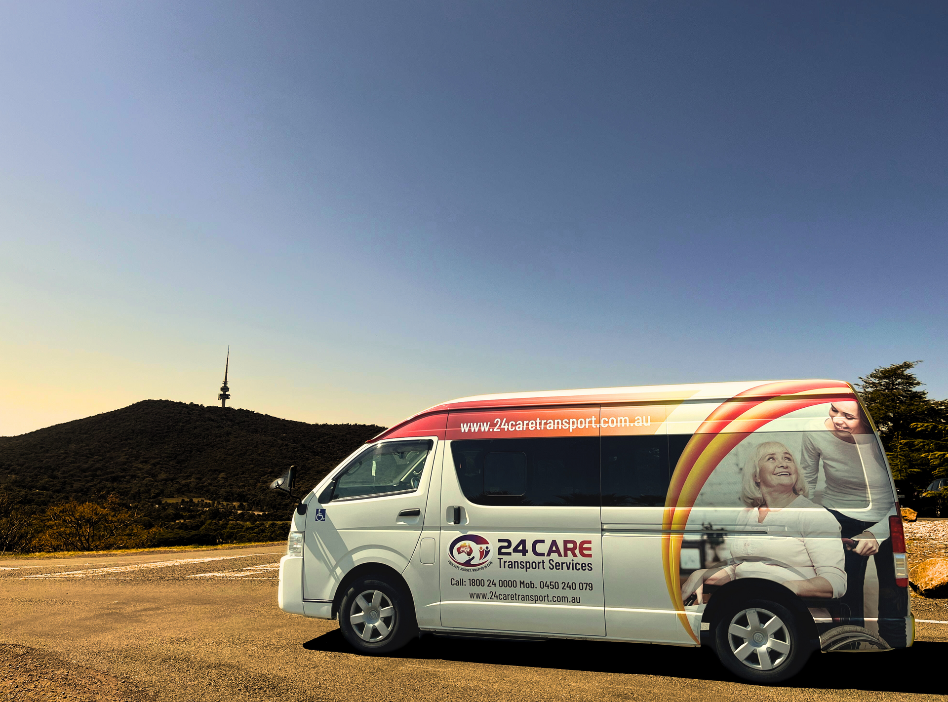 A 24 care van is parked in a parking lot with a mountain in the background.