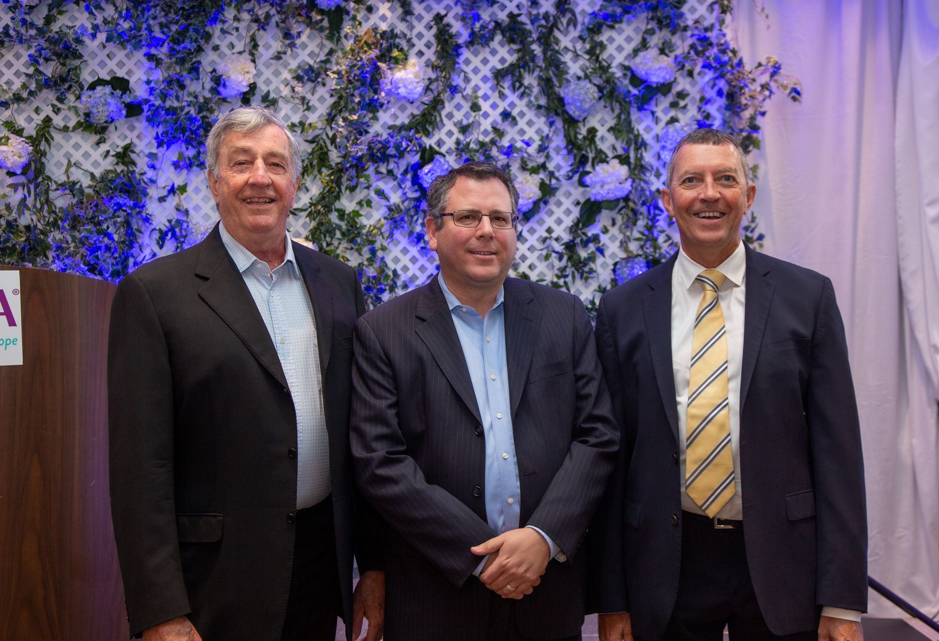 Three men in suits and ties are posing for a picture.