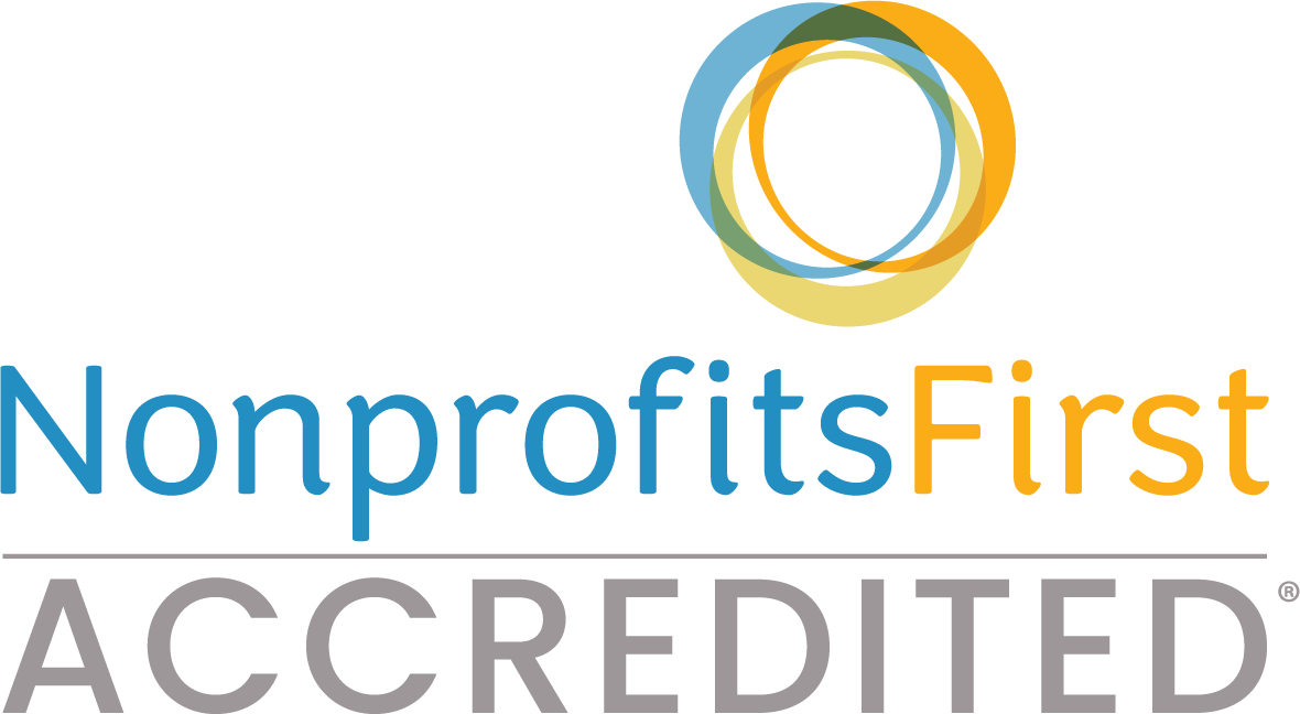 A logo for nonprofits first accredited with a blue and orange circle