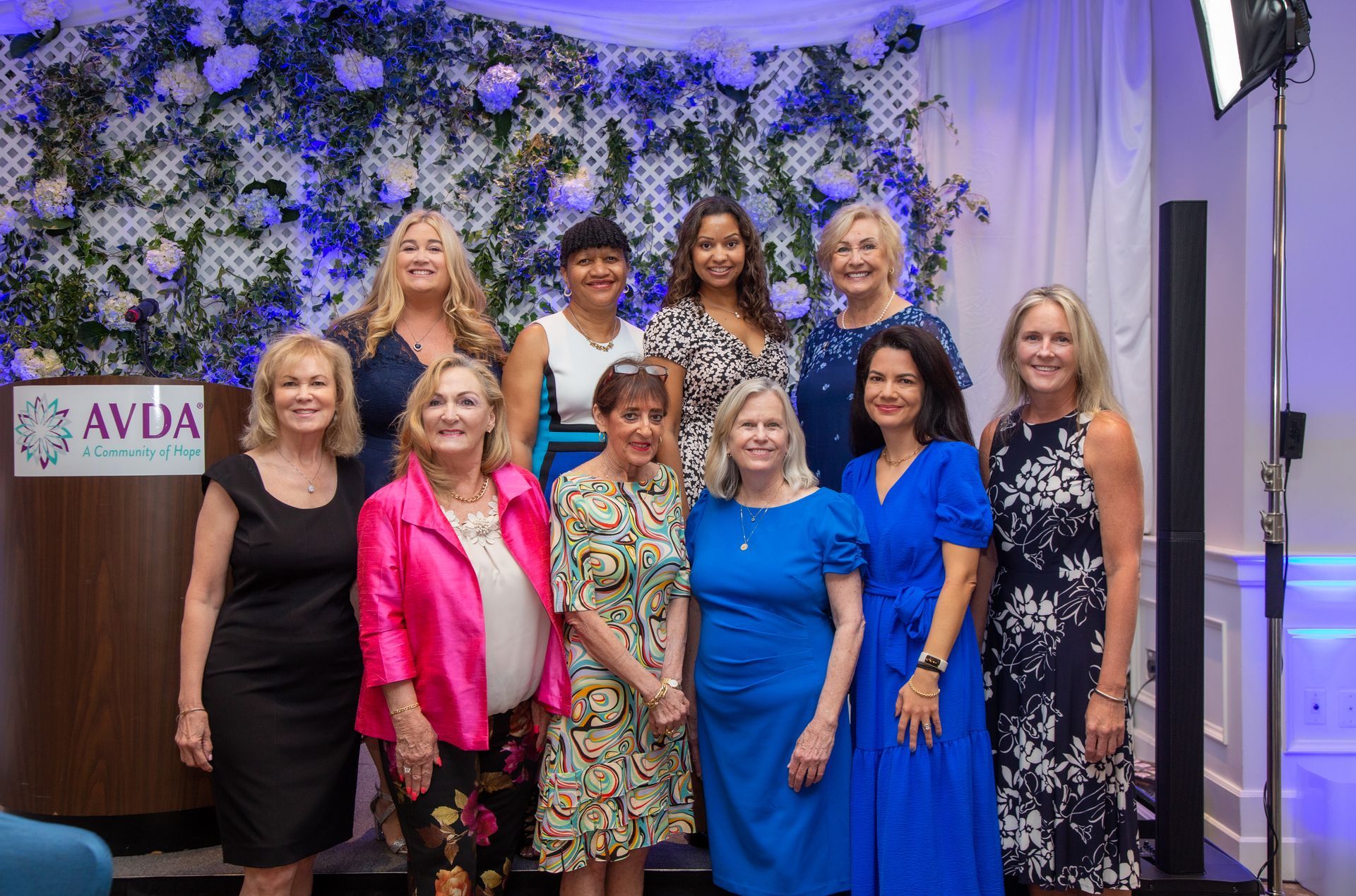 A group of women are posing for a picture in front of a podium.