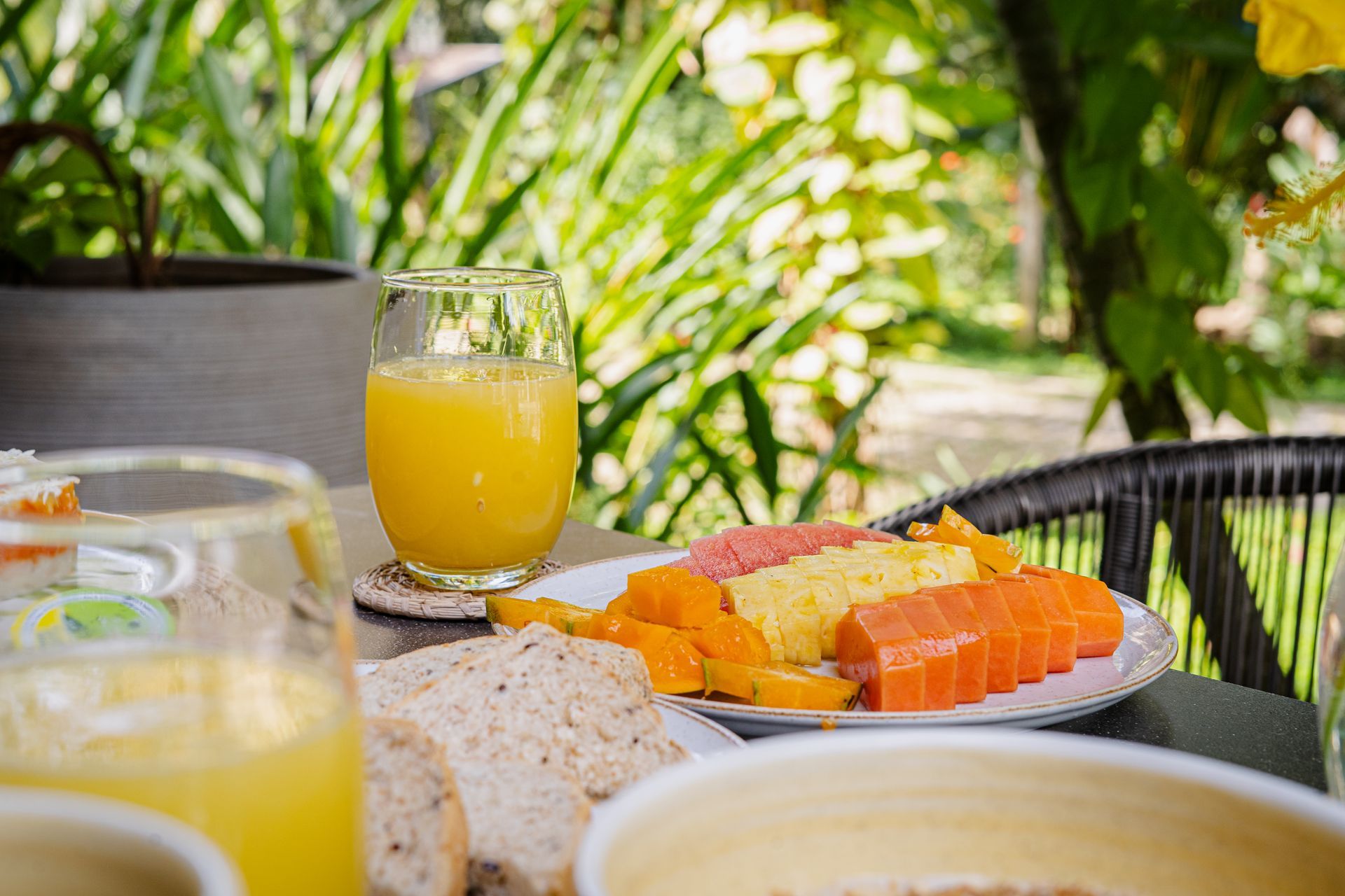Montañas verdes, antiguas estructuras de piedra y exuberantes árboles tropicales bajo un cielo azul.