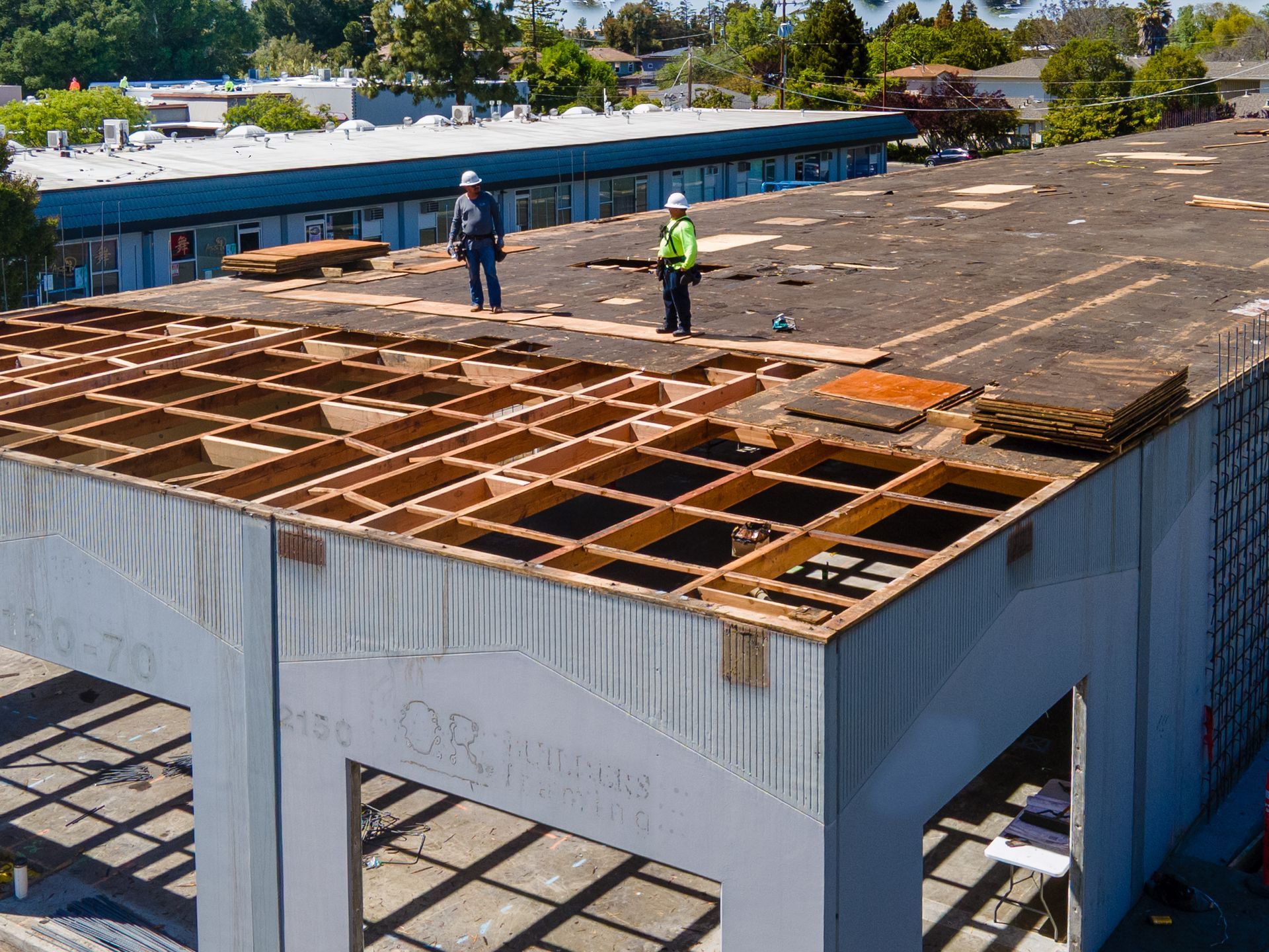 Two men are working on the roof of a building.