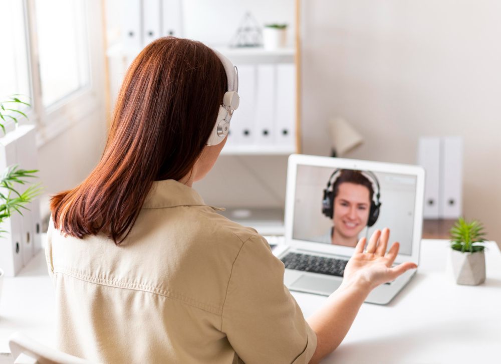 A woman is having a video call with a man on a laptop computer.