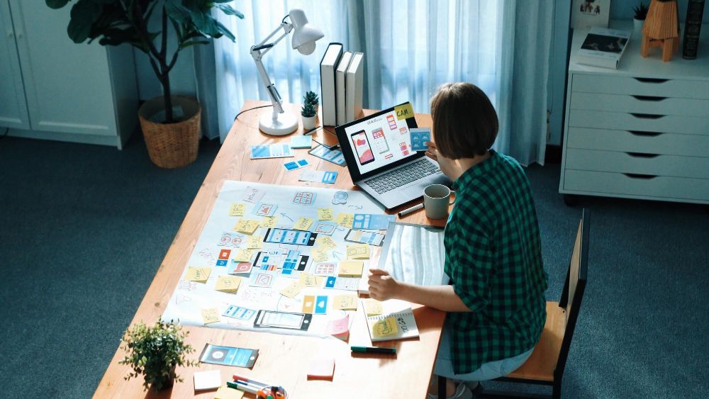 A man is sitting at a desk using a laptop computer.