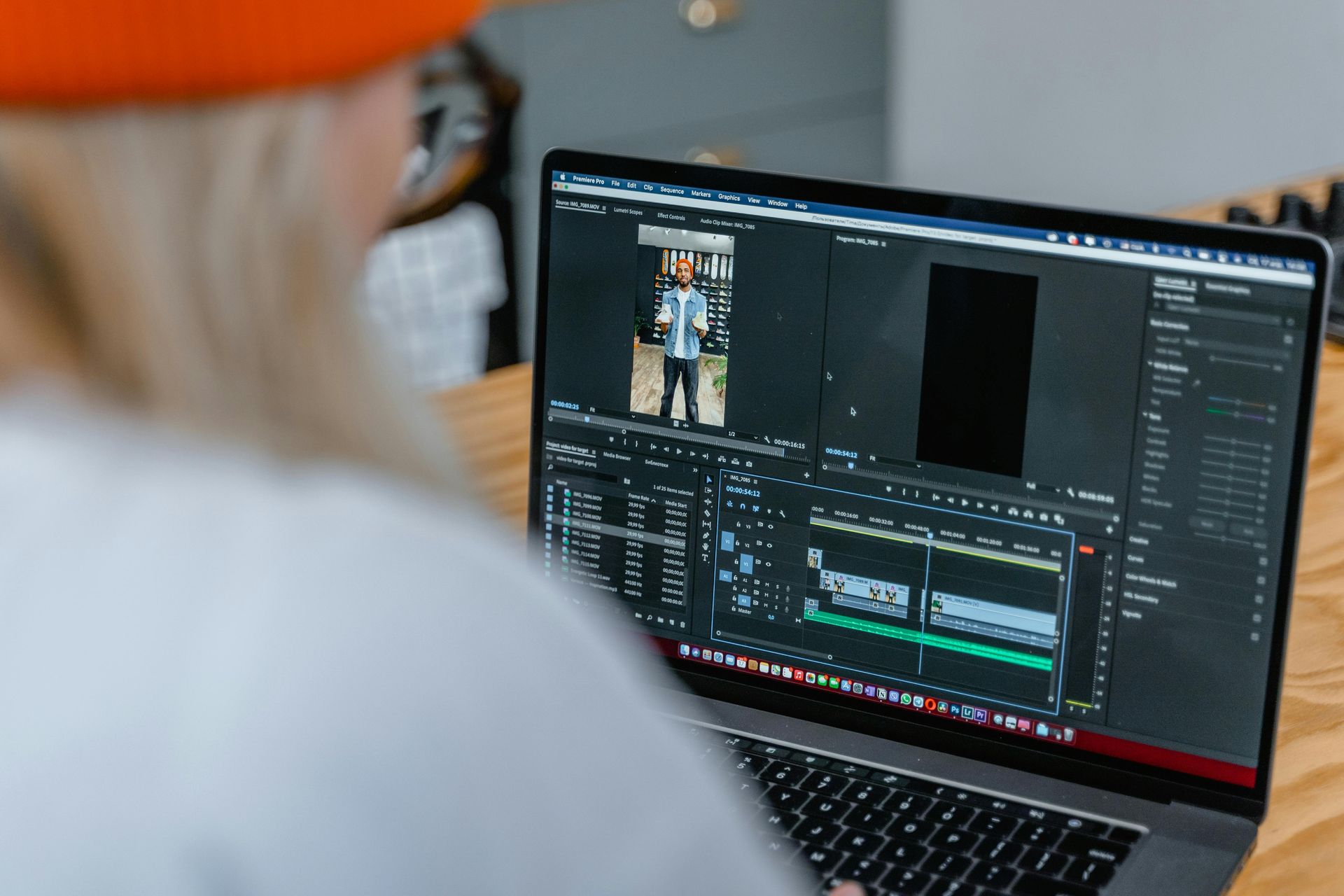 A woman is using a laptop computer to edit a video.