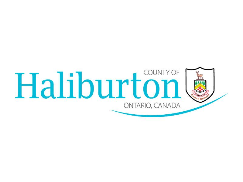 The logo for the County of Haliburton, Ontario, featuring teal text and a crest with a deer on a white background.