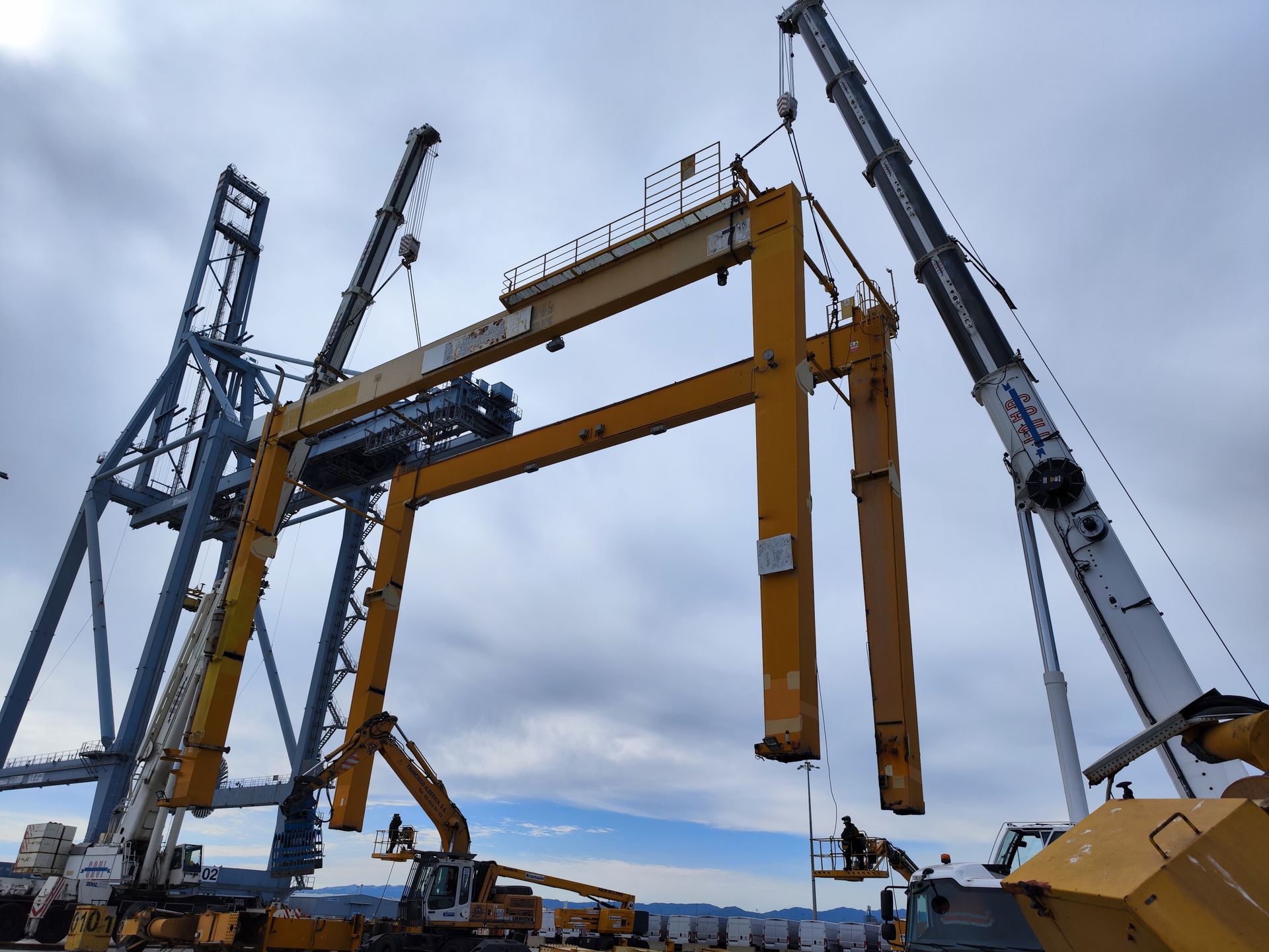 Se está construyendo una gran grúa amarilla en un puerto.